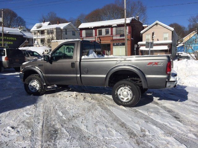 a ford truck is parked in a snowy parking lot