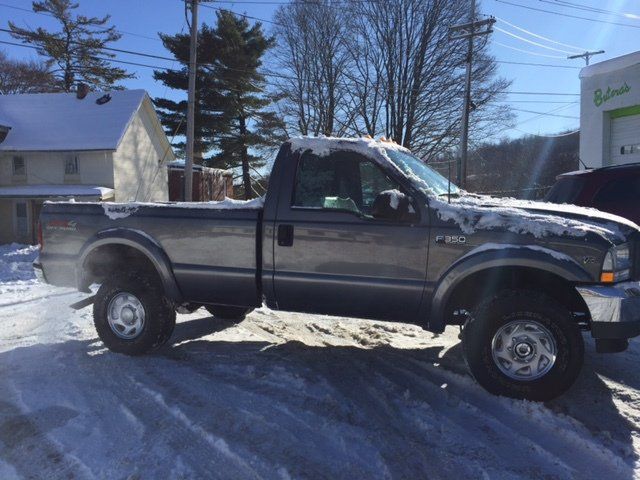 a gray ford f250 truck is parked in the snow