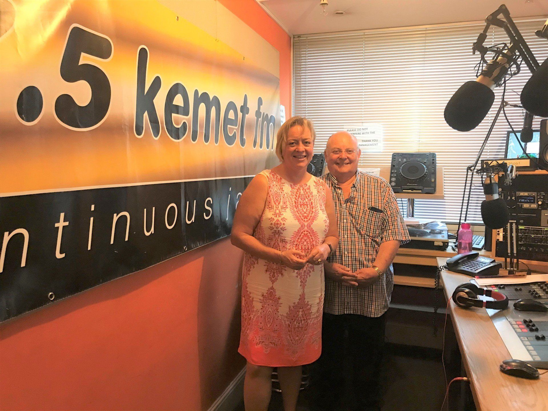 two women are standing in front of a sign that says 5 kemet