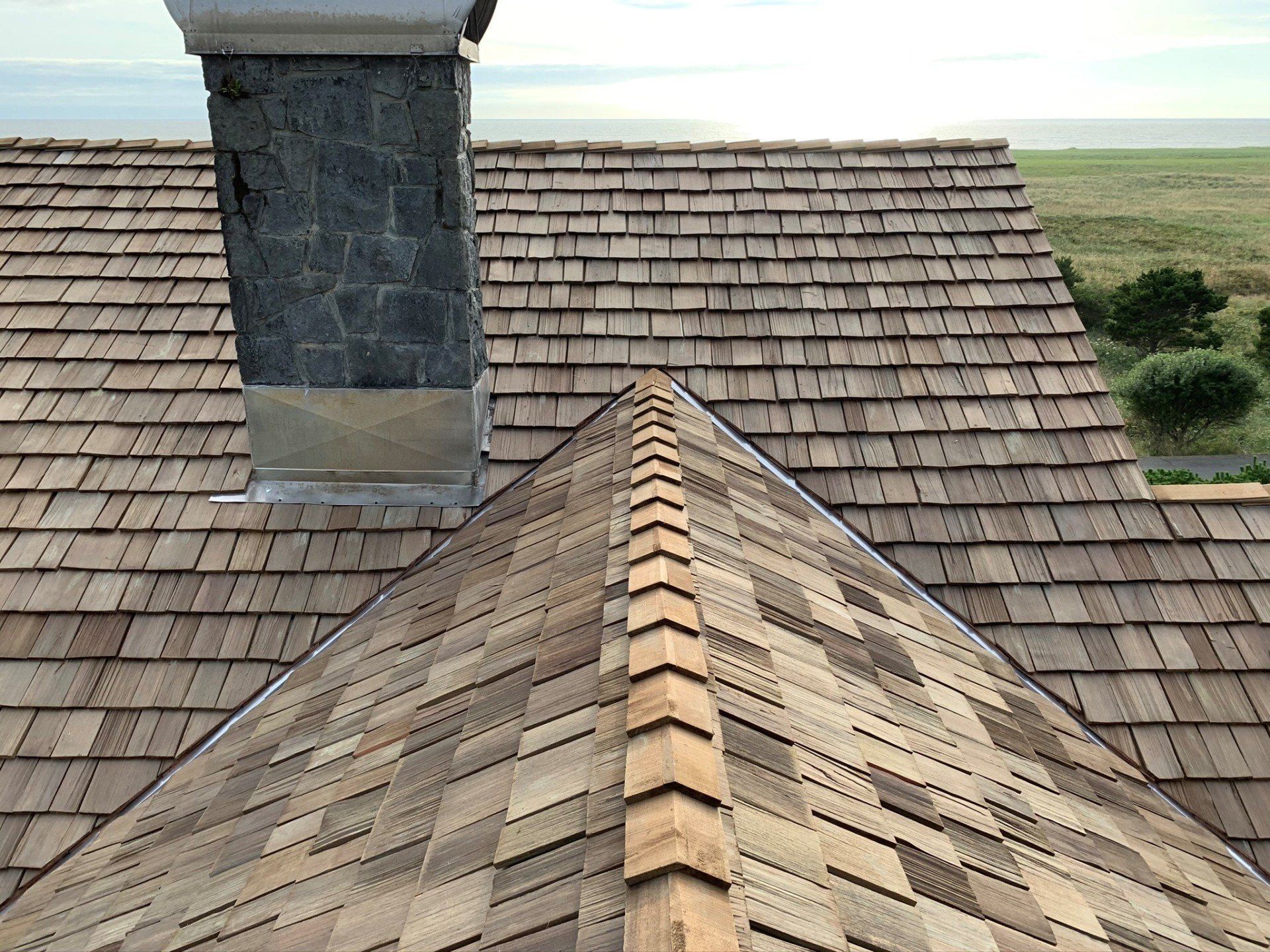 Wooden shingle roof with a chimney, angled perspective.