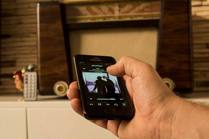 A person is holding a cell phone to control de radio