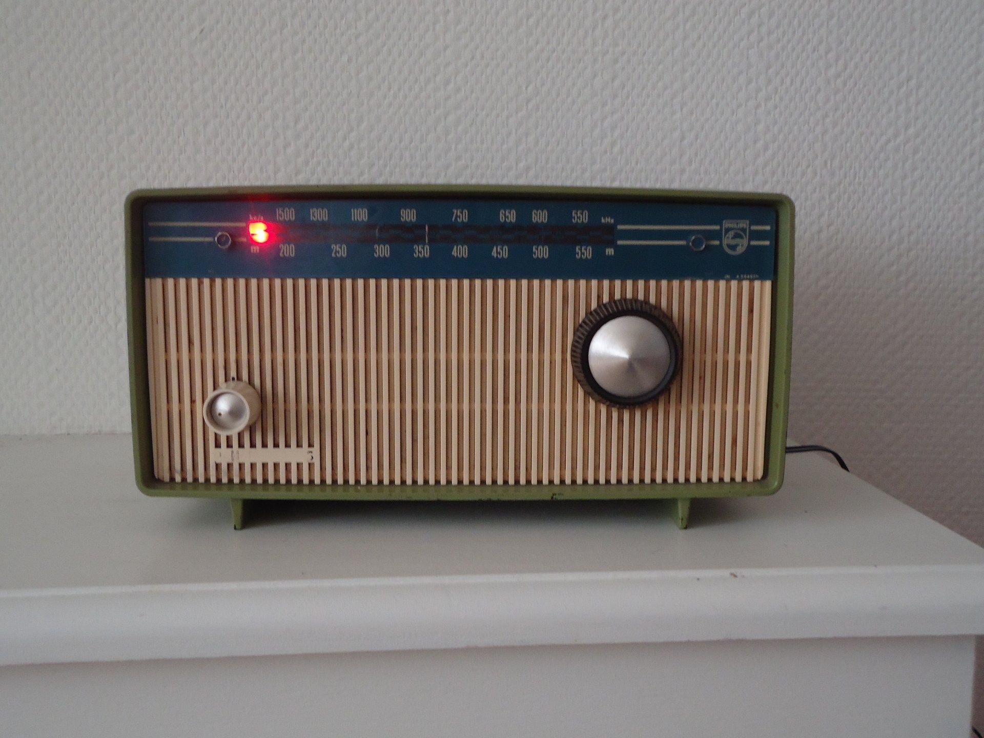 A green radio with a knob on the top of it