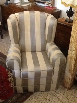 Poltrona a righe nei colori grigio chiaro e crema.