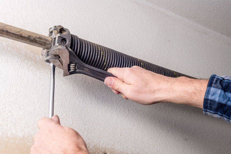 A man fixing a garage door spring.