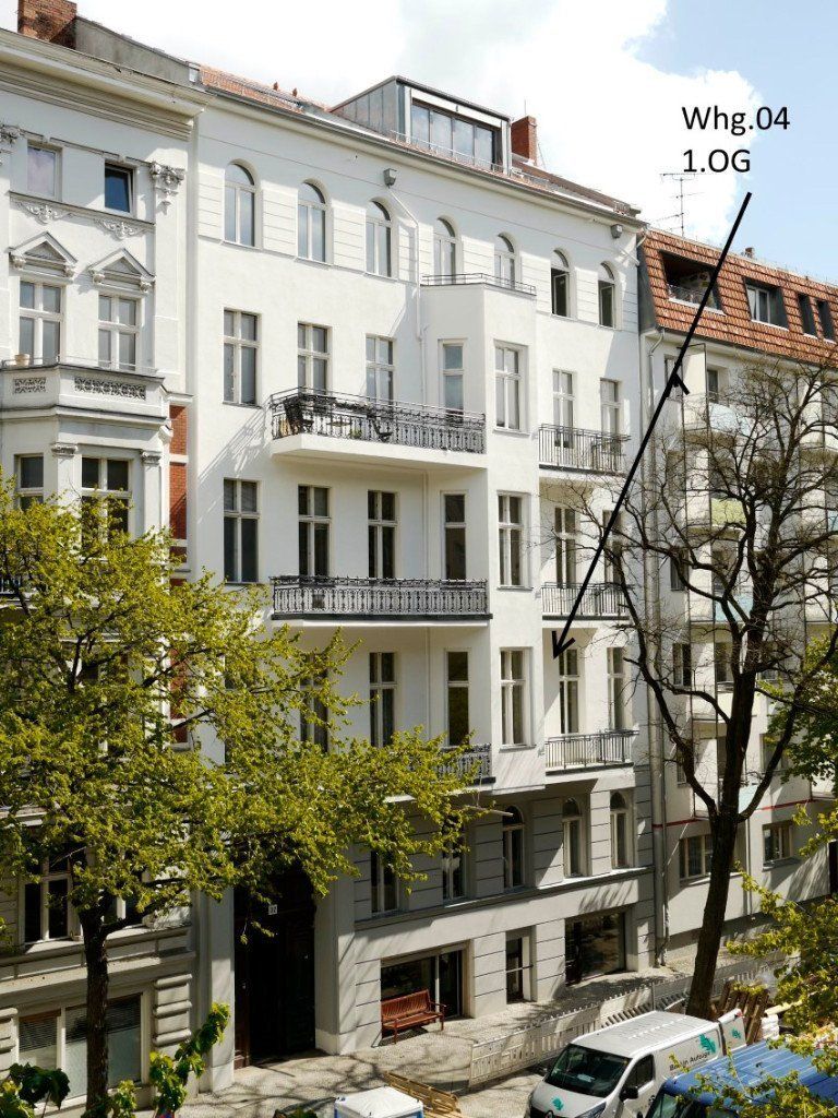 Ein großes weißes Gebäude mit einem Baum davor