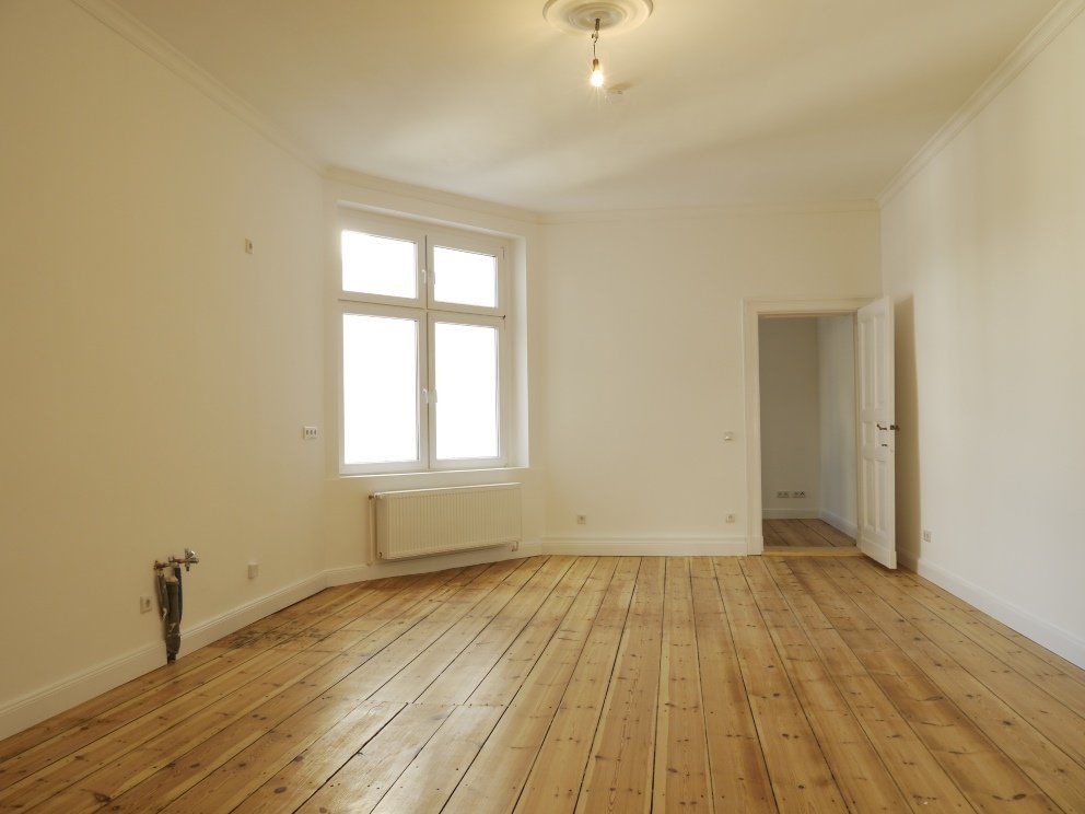 Ein leerer Raum mit Holzböden und weißen Wänden