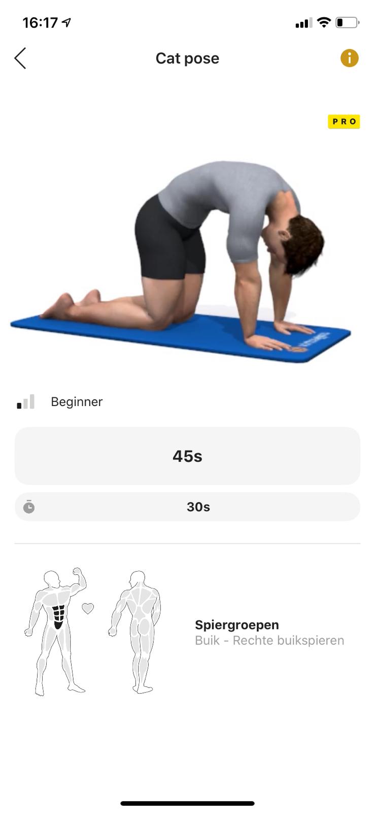 een man doet een kattenpose op een yogamat.