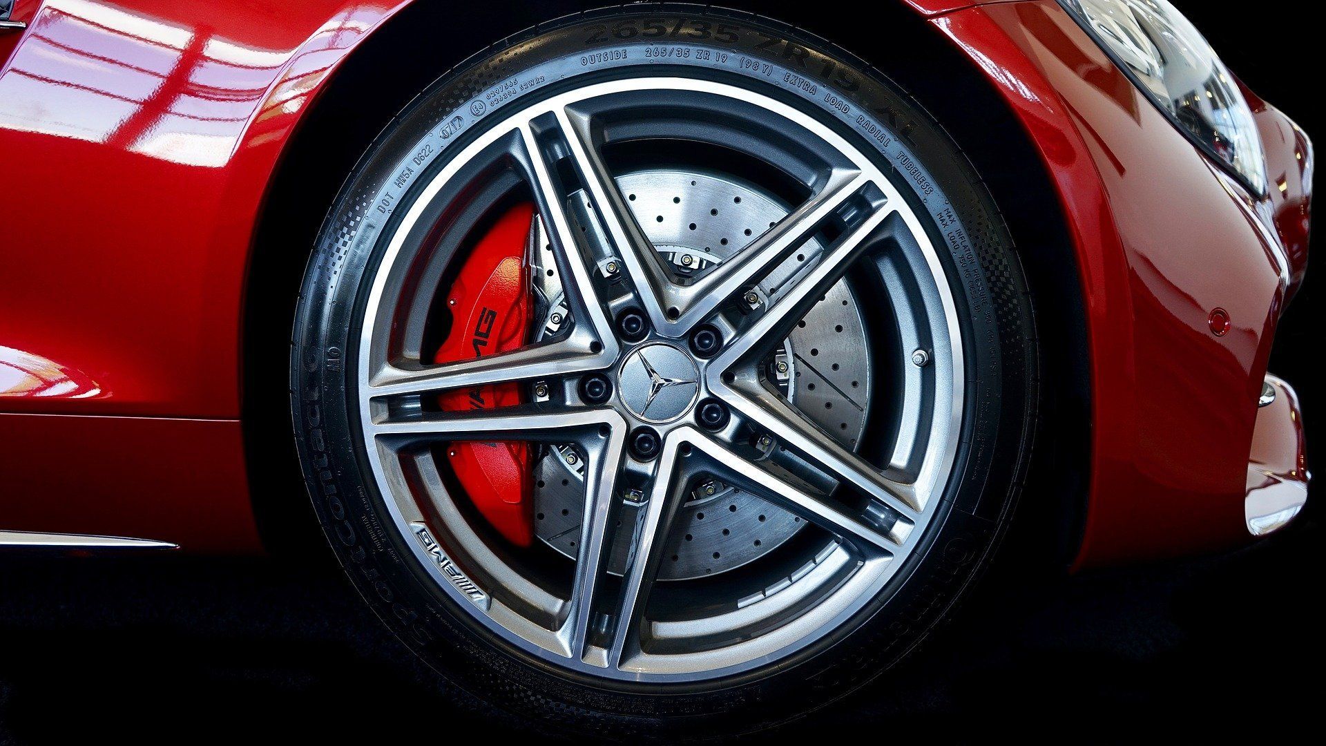 Red car wheel with a silver and black rim, and red brake caliper.