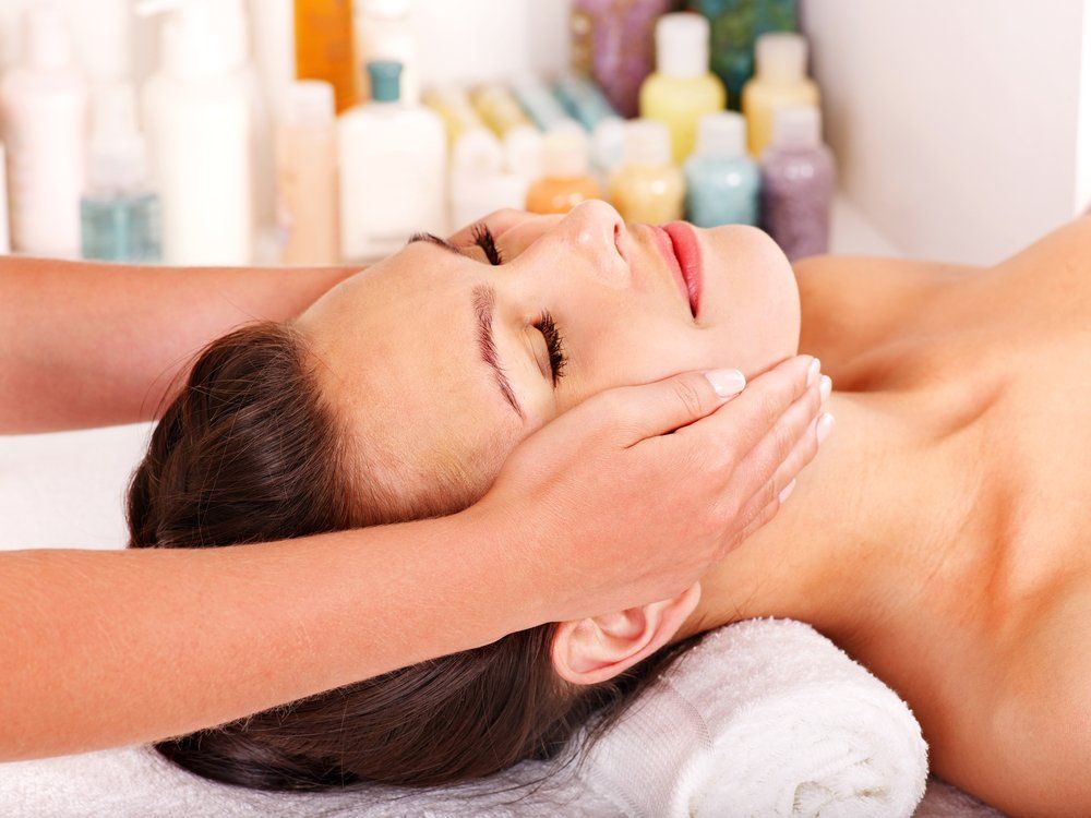 Eine Frau bekommt in einem Spa eine Gesichtsmassage.