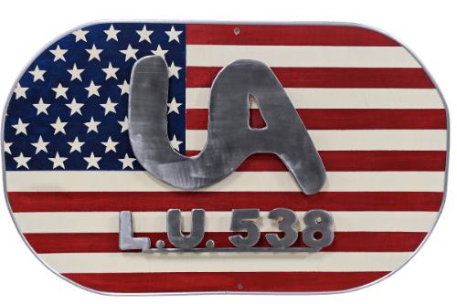 Learn More About UA Local 538 custom steel art created by apprentices at Local 538. Oval shaped with USA flag background and text in shiny steel reading UA L.U. 538