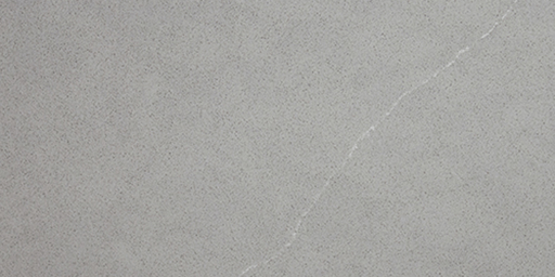 A close-up view of a matte grey, speckled countertop surface featuring a single, thin, white diagonal vein.