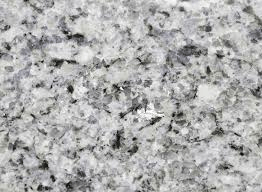 A close-up view of a light gray granite surface with speckled black, white, and clear mineral flecks.