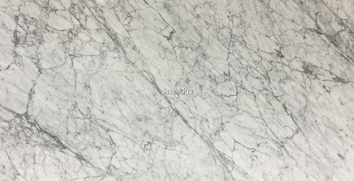 Close-up of white marble slab with intricate grey veining patterns throughout.
