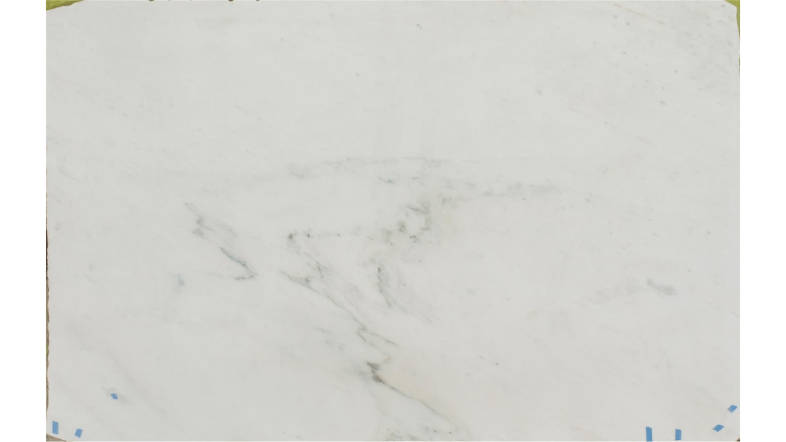 A slab of white marble featuring subtle, light grey veining throughout the surface.