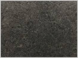 A close-up, high-angle view of a textured, dark gray concrete or stone surface with subtle mottled variations.