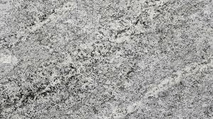 A close-up view of a grey and white granite stone surface with a speckled, textured pattern.