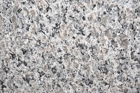 Close-up of a polished granite stone slab with a speckled pattern in shades of gray, black, and white.