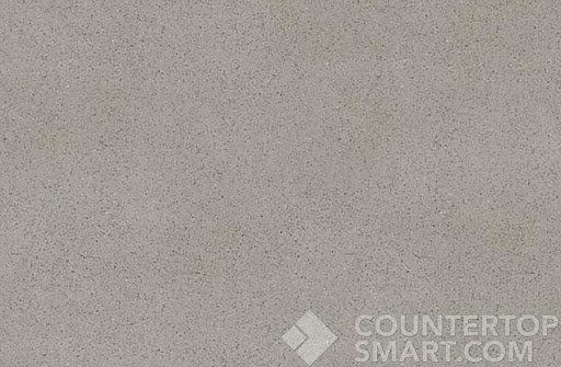 A flat, close-up texture sample of a uniform, light gray quartz countertop material.