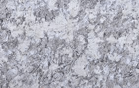 A close-up view of granite stone with a speckled, mottled pattern of white, light gray, and dark charcoal minerals.