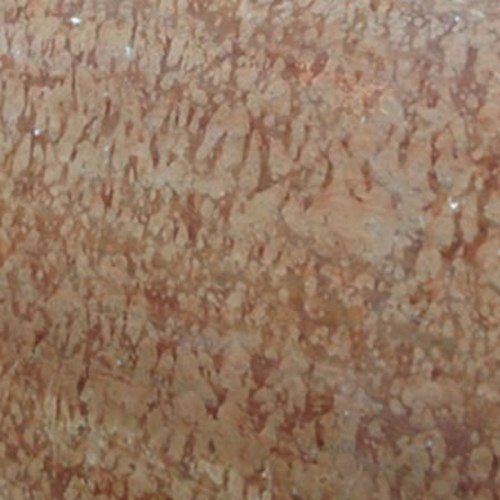 A close-up view of polished, warm-toned stone with an intricate, mottled pattern in shades of peach, tan, and light brown.