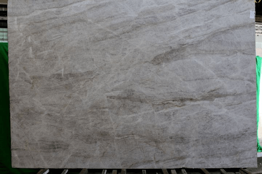Large slab of light gray marble featuring horizontal, darker gray veining patterns and a polished finish.