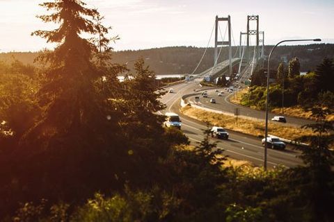 aAn image of cars crossing the Tacoma Narrows Bridge at sunset. The Tacoma Narrows bridge is actually two twin suspension bridges spanning the Puget Sound, Washington State, USA. State Route 16 connects to the Kitsap Peninsula and close towns such as Gig Harbor, Port Orchard, and Bremerton.
