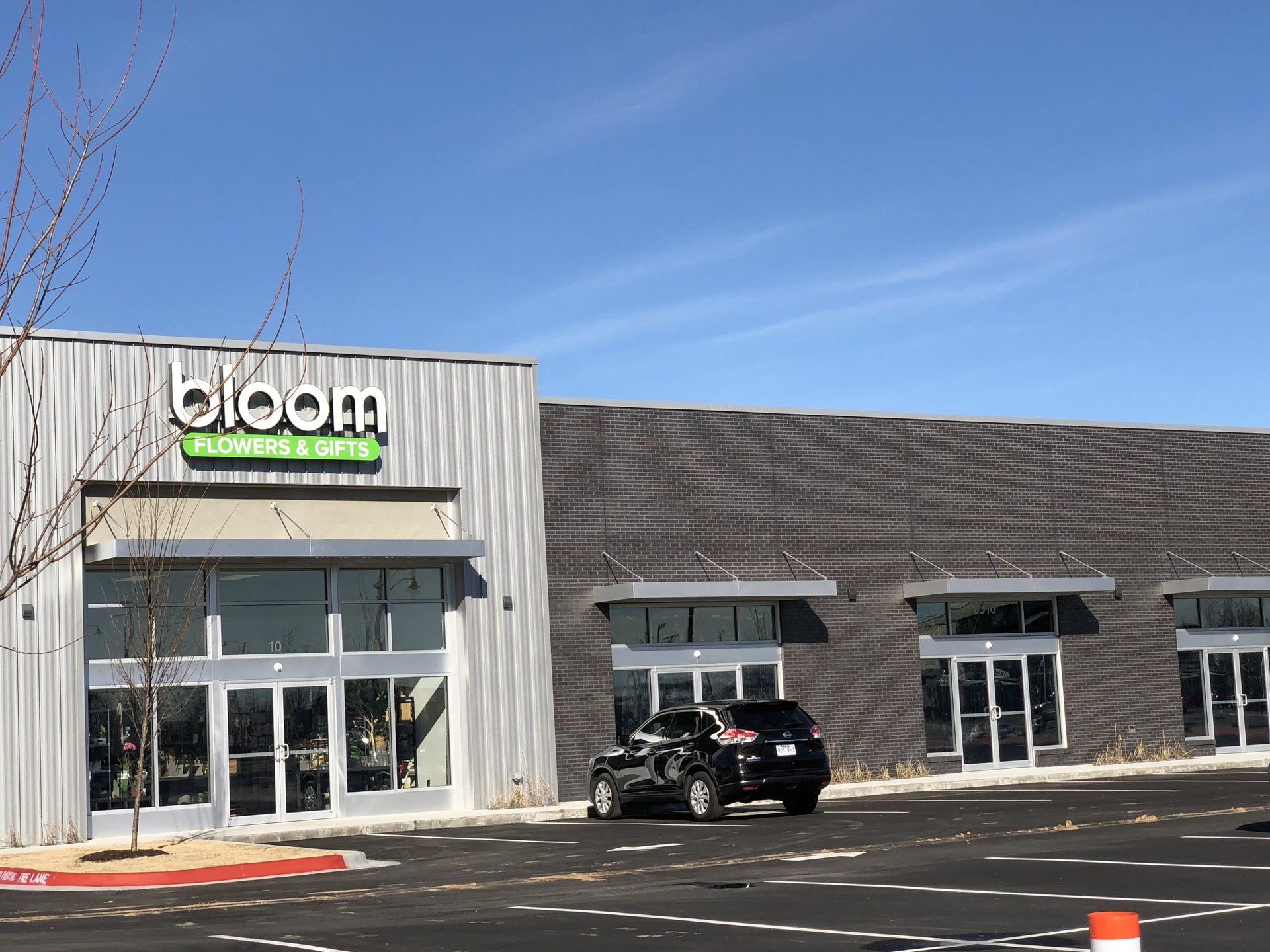 Bloom Wellness & Spa building with a car parked outside on a sunny day.