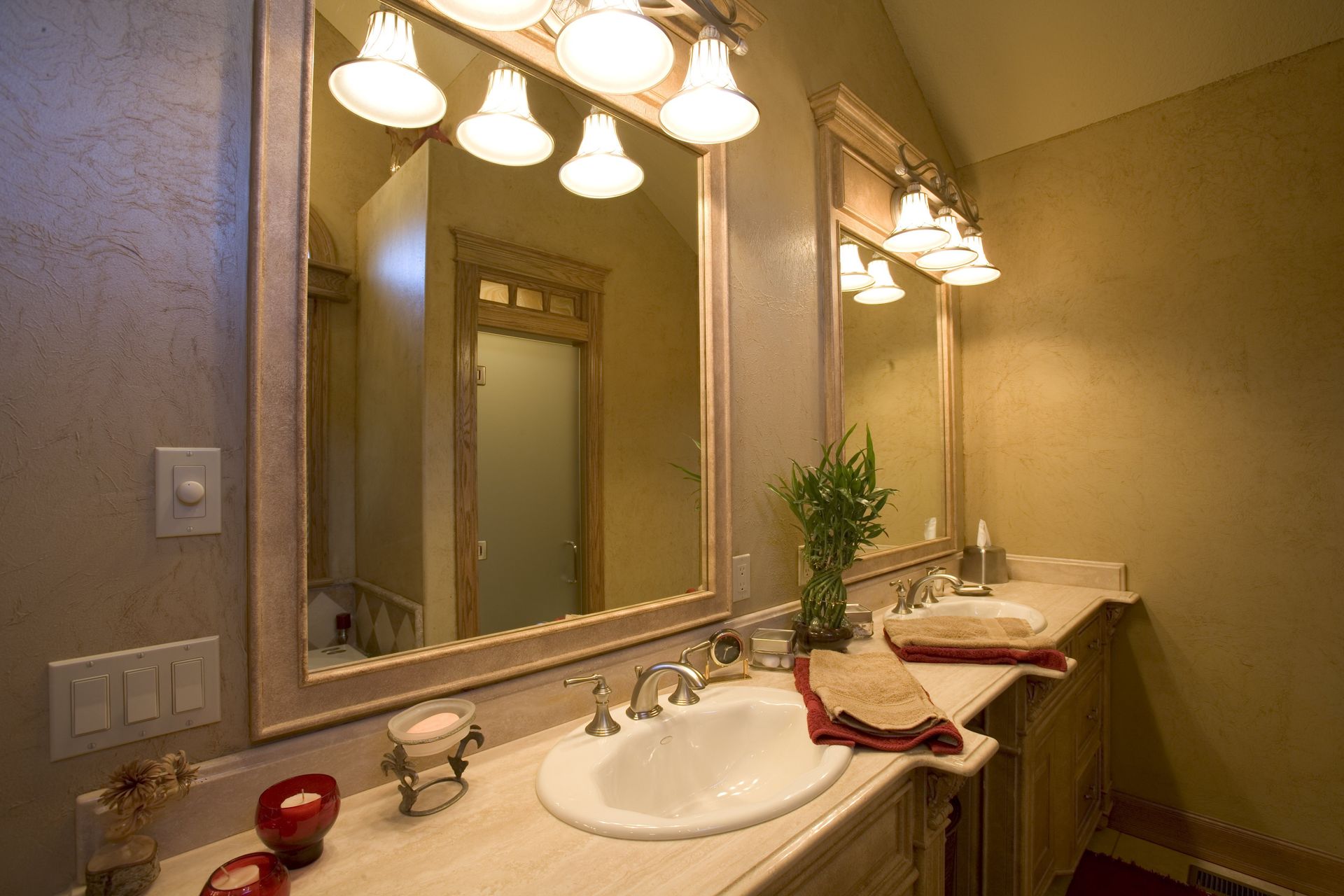 Bathroom with two sinks, large mirrors, and sconce lighting.