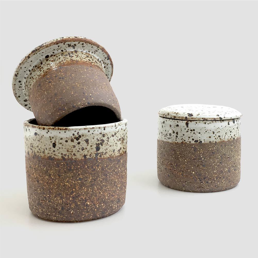 two ceramic butter containers in speckled brown and white