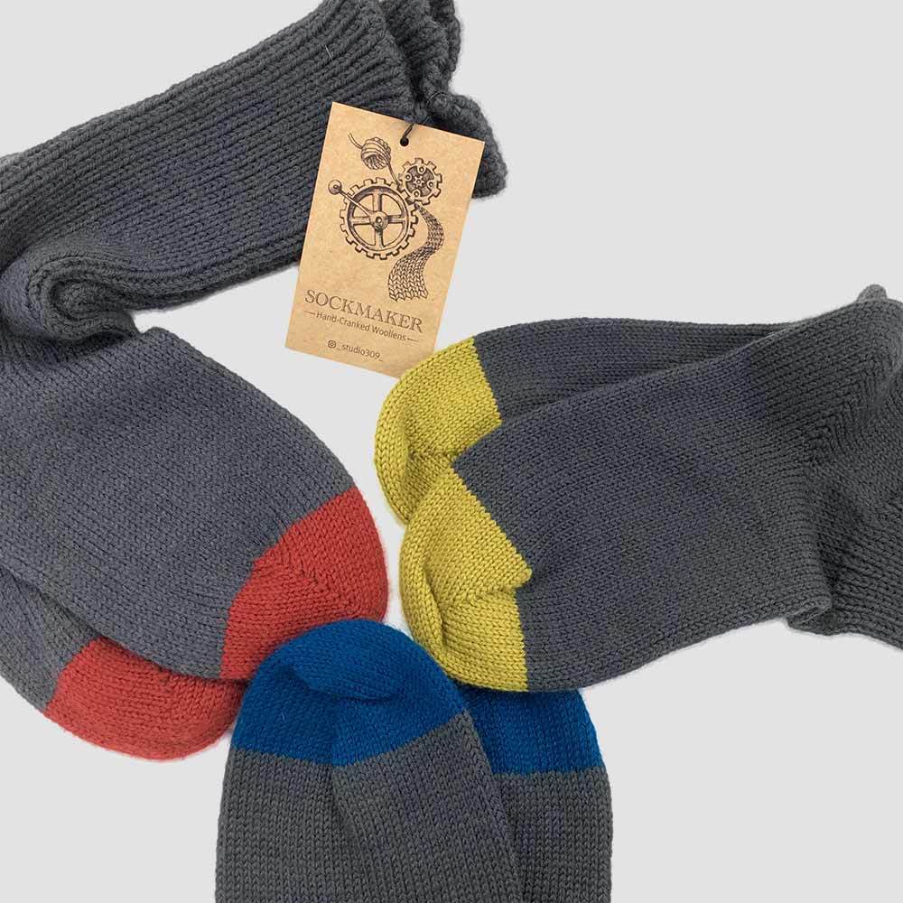 three pairs of grey woollen socks with colourful tips, made by Linda Castles