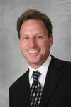 A man in a suit and tie is smiling for the camera.