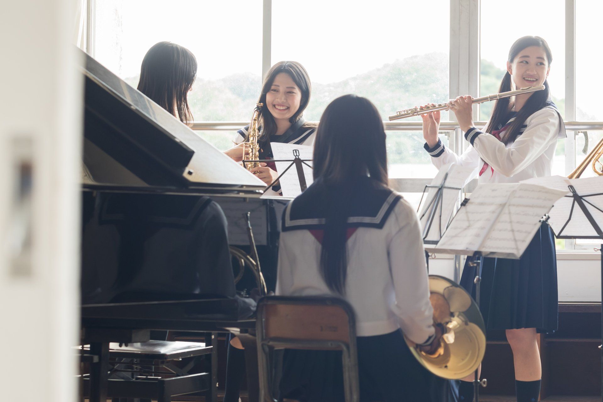 學生們在明亮的房間裡練習音樂,房間裡有鋼琴、長笛和樂譜架。