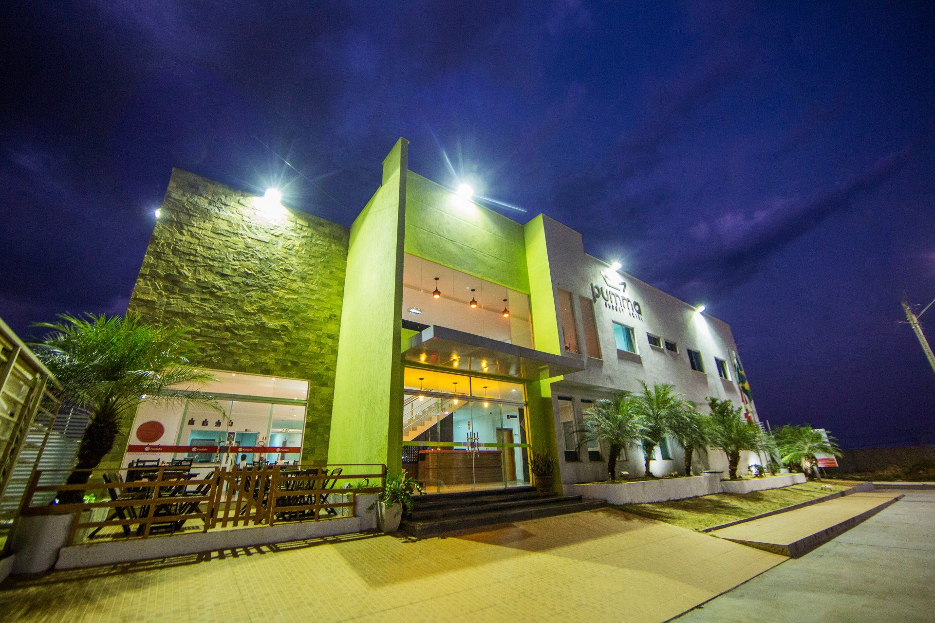 Um grande edifício com uma fachada verde é iluminado à noite