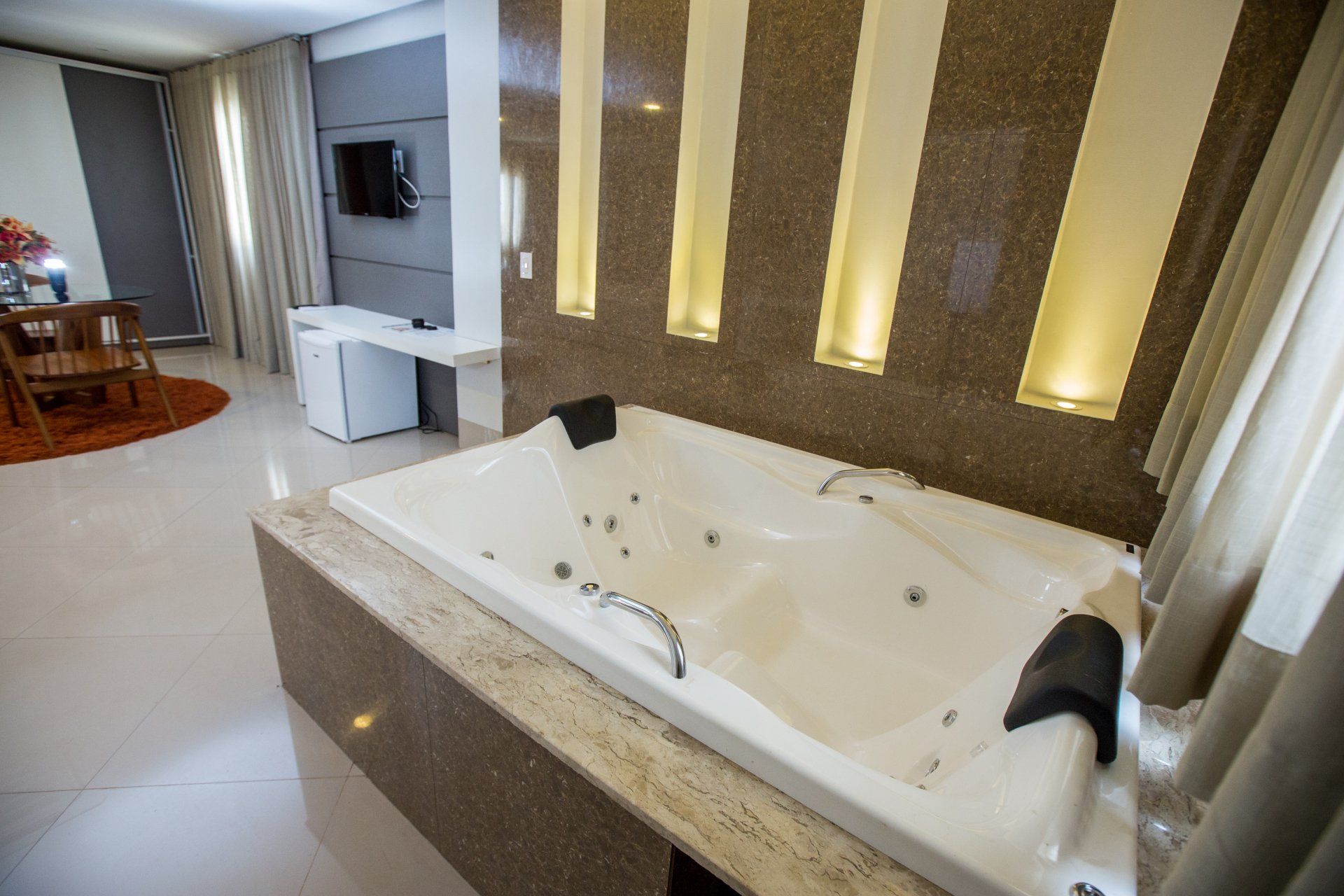 Há uma grande banheira de hidromassagem no meio do quarto.