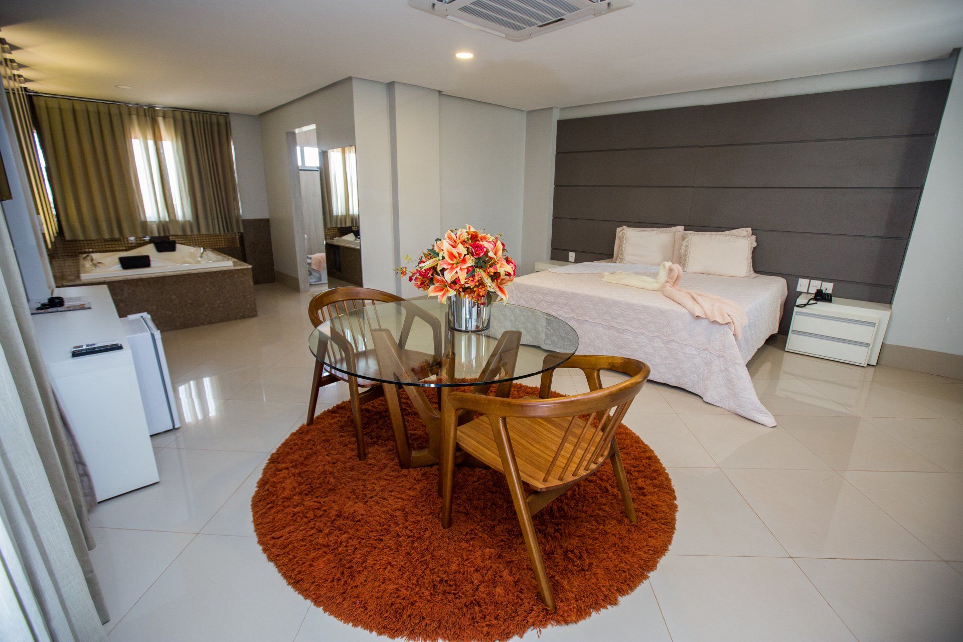Um quarto de hotel com uma cama grande, uma mesa e cadeiras