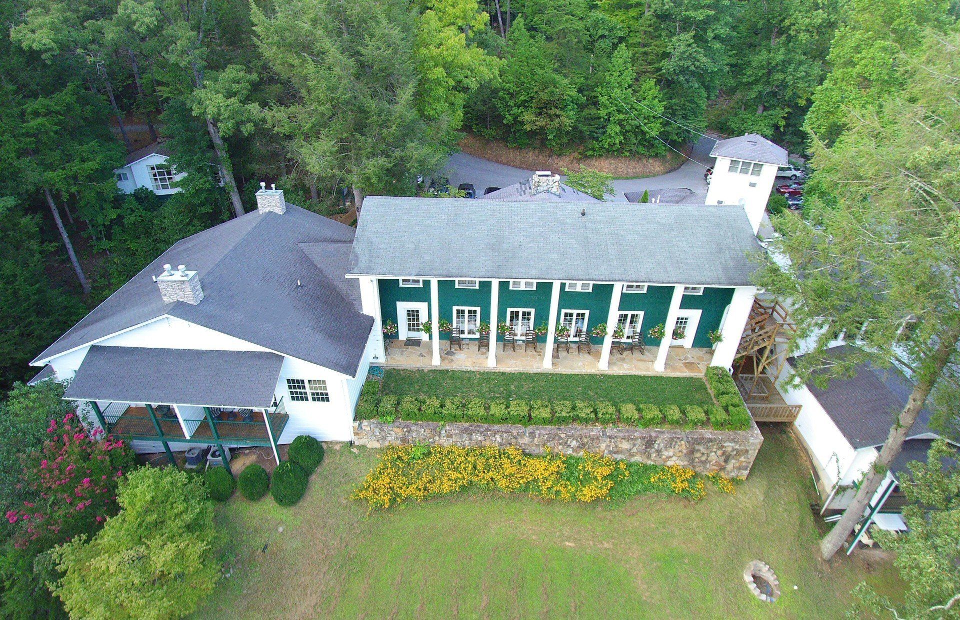 An aerial view of a large white house surrounded by trees.