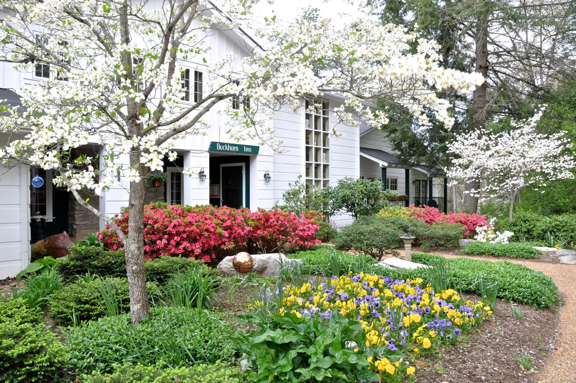 A white house with flowers in front of it