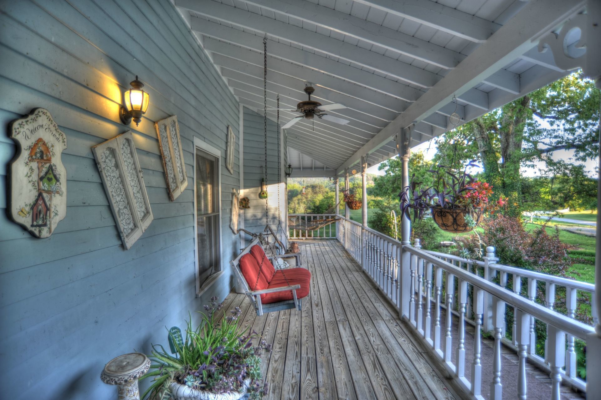 A porch with a red chair and a ceiling fan