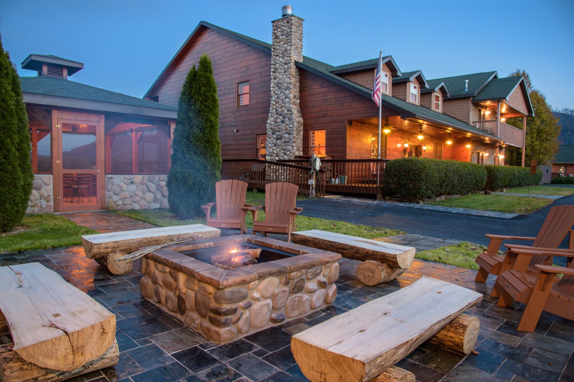There is a fire pit in front of a large house.