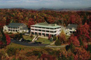 An aerial view of a large building in the middle of a forest.