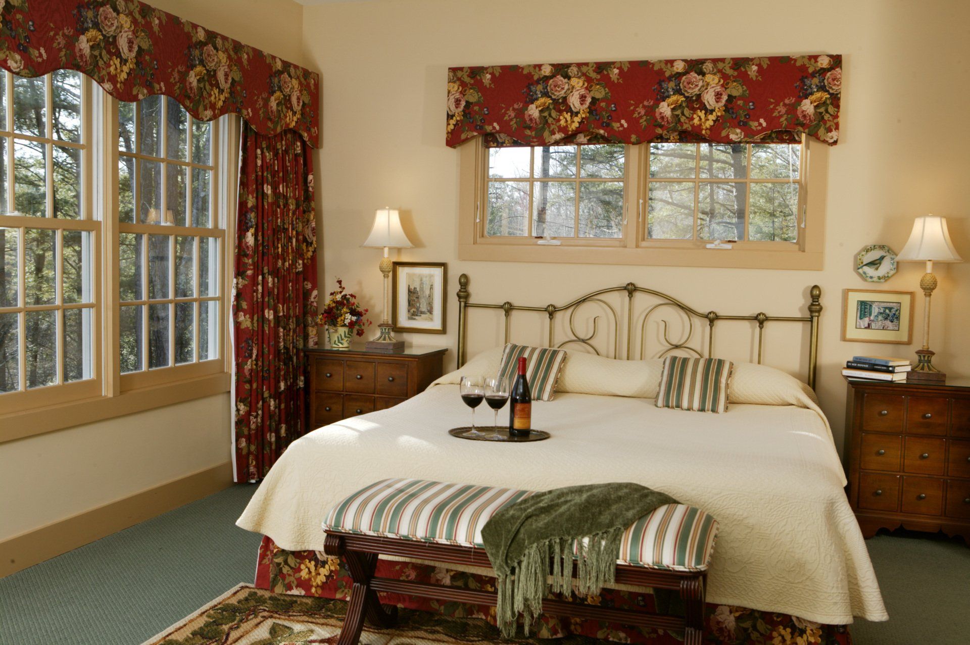 A bedroom with a king size bed and two glasses of wine
