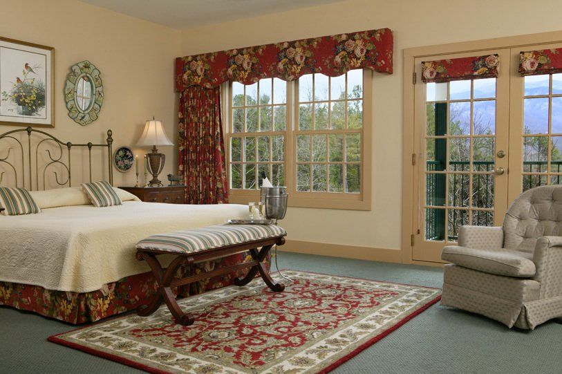 A bedroom with a king size bed and a chair