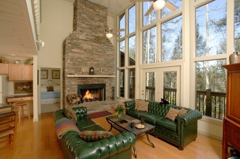 A living room with a fireplace and lots of windows