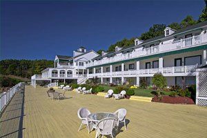 A large white building with a large deck in front of it.