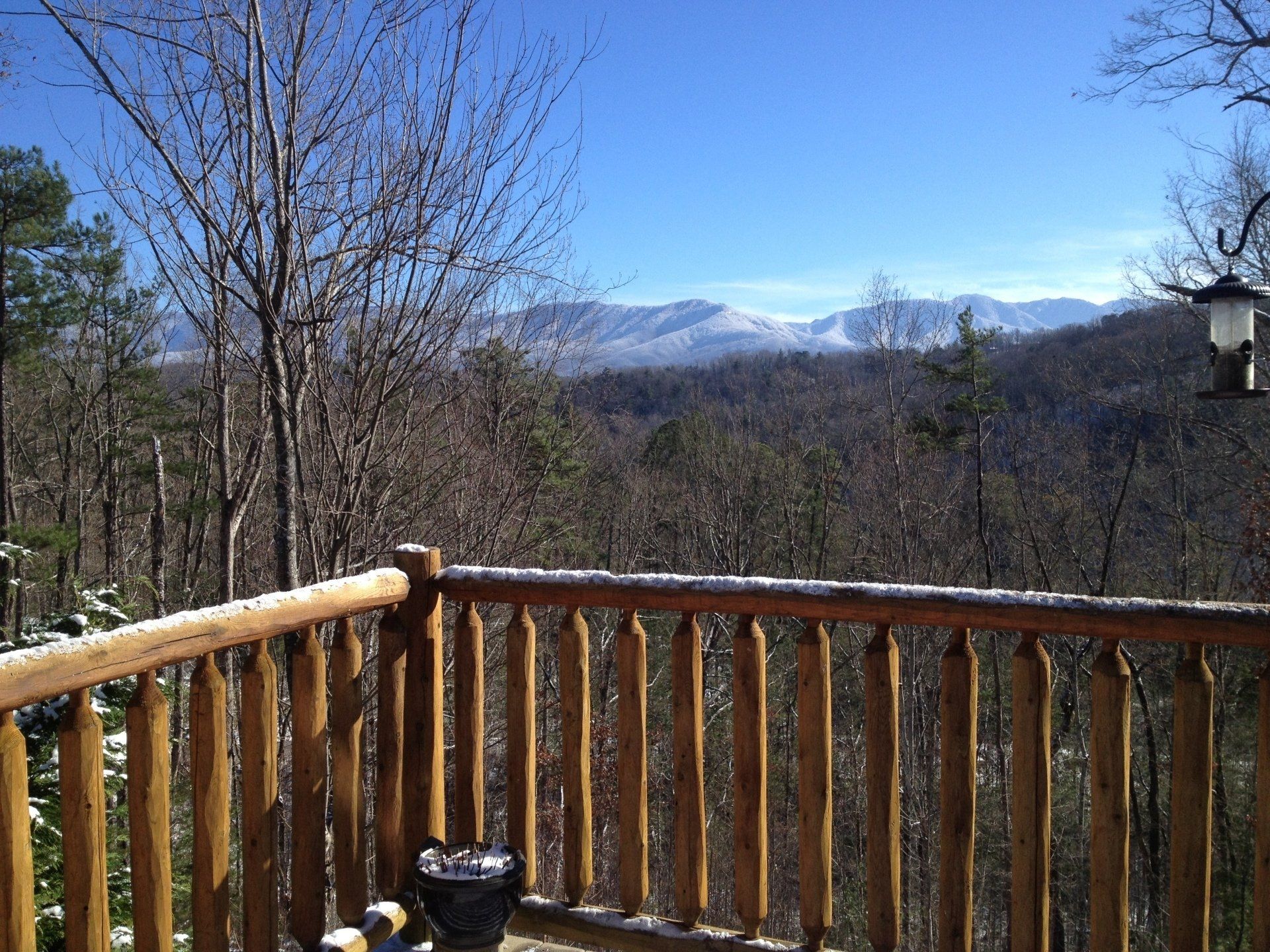 A wooden deck with a view of mountains and trees