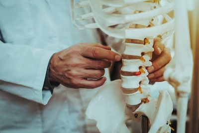 Doctor Holding And Showing Vertebrae On Skeleton — Tyler, TX — Tyler Chiropractic Doctor Holding And Showing Vertebrae On Skeleton — Tyler, TX — Tyler Chiropractic