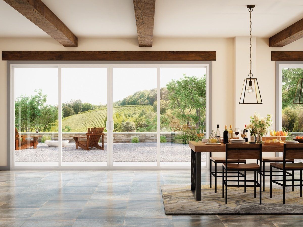 A dining room with a table and chairs and sliding glass doors leading to a patio.