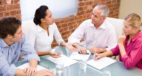 A group of people sitting around a table talking
