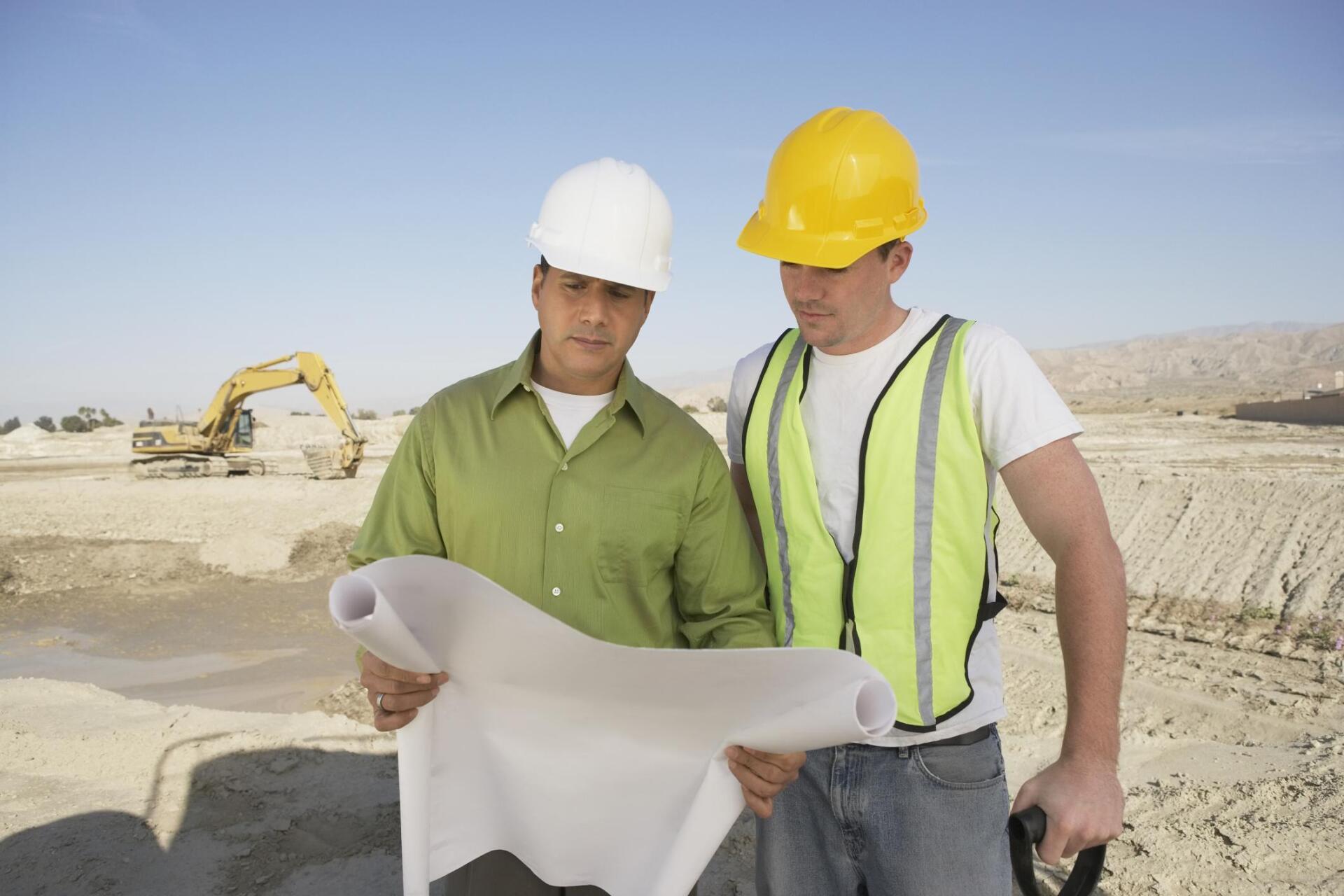 worker and engineer looking at the blueprint