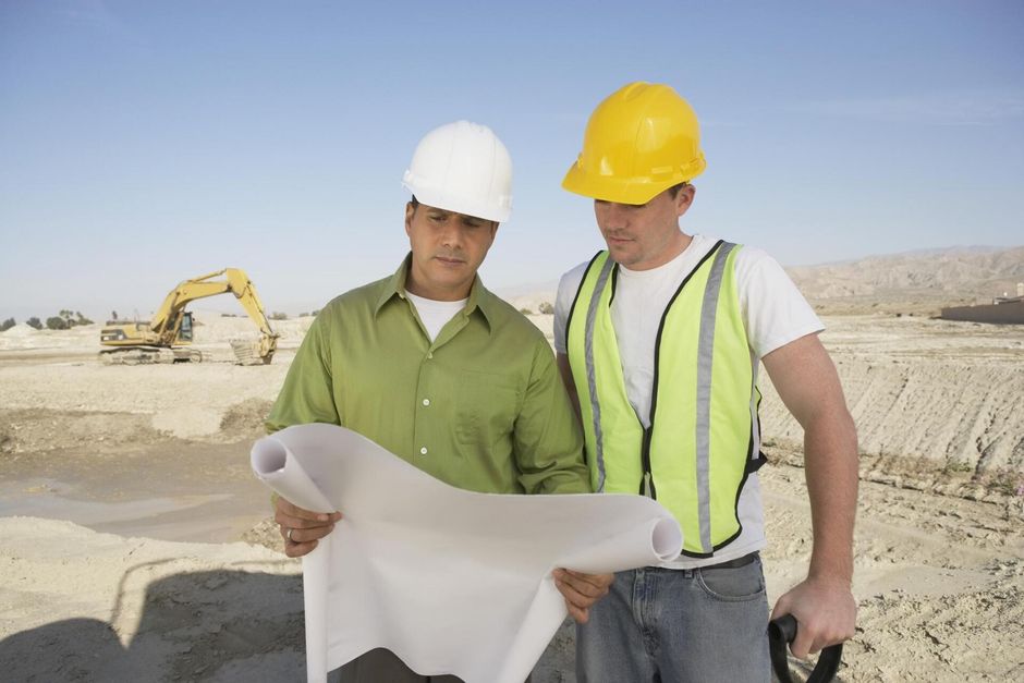 worker and engineer looking at the blueprint